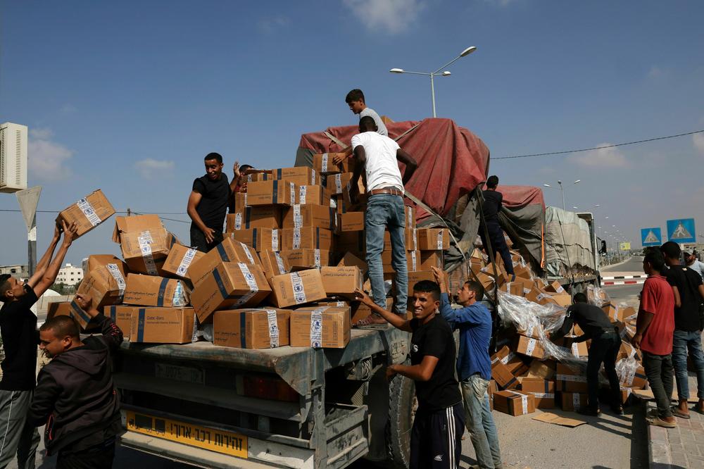 People reload fallen boxes onto a truck carrying humanitarian aid that entered the southern Gaza Strip from Egypt via the Rafah border crossing on Nov. 2, as battles between Israel and the Palestinian Hamas movement continue.
