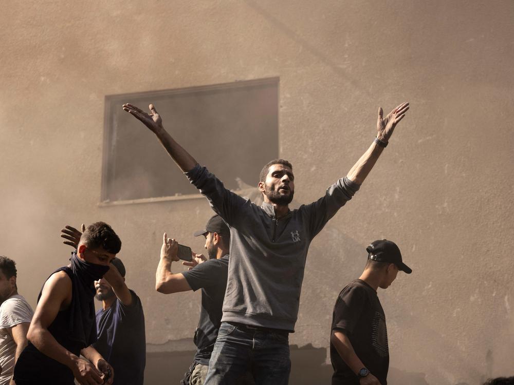 A Palestinian man reacts as others check the rubble of a building in Khan Younis, Gaza Strip, on Monday as battles continue between Israel and the Palestinian group Hamas.