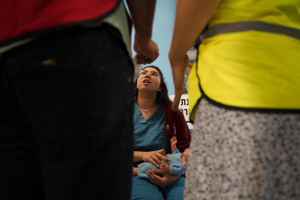 Lipaz Zira play acts as a patient with a baby in a drill in the underground hospital in Haifa.