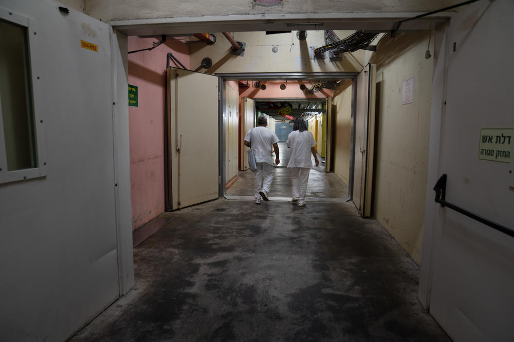 Hospital employees walk underground in a hallway at Galilee Medical Center, a community hospital in Nahariya, in northern Israel.