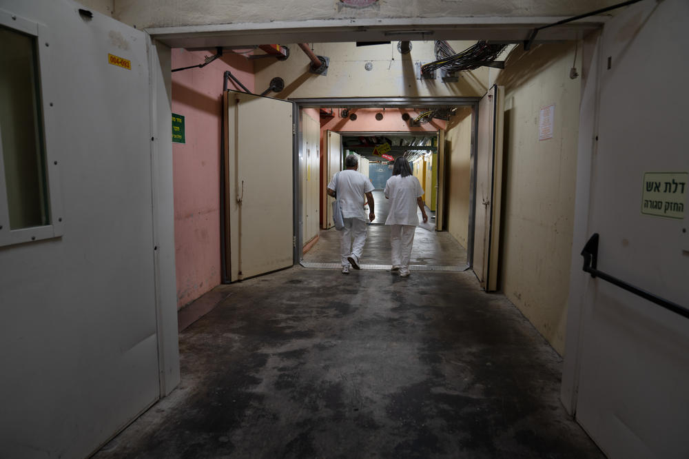 Hospital employees walk underground in a hallway at Galilee Medical Center, a community hospital in Nahariya, in northern Israel.