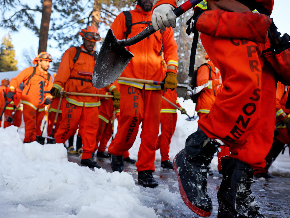 A crew of prisoner firefighters walk back to their vehicle on March 3 after shoveling and clearing snow after a series of winter storms in the San Bernardino Mountains in California.