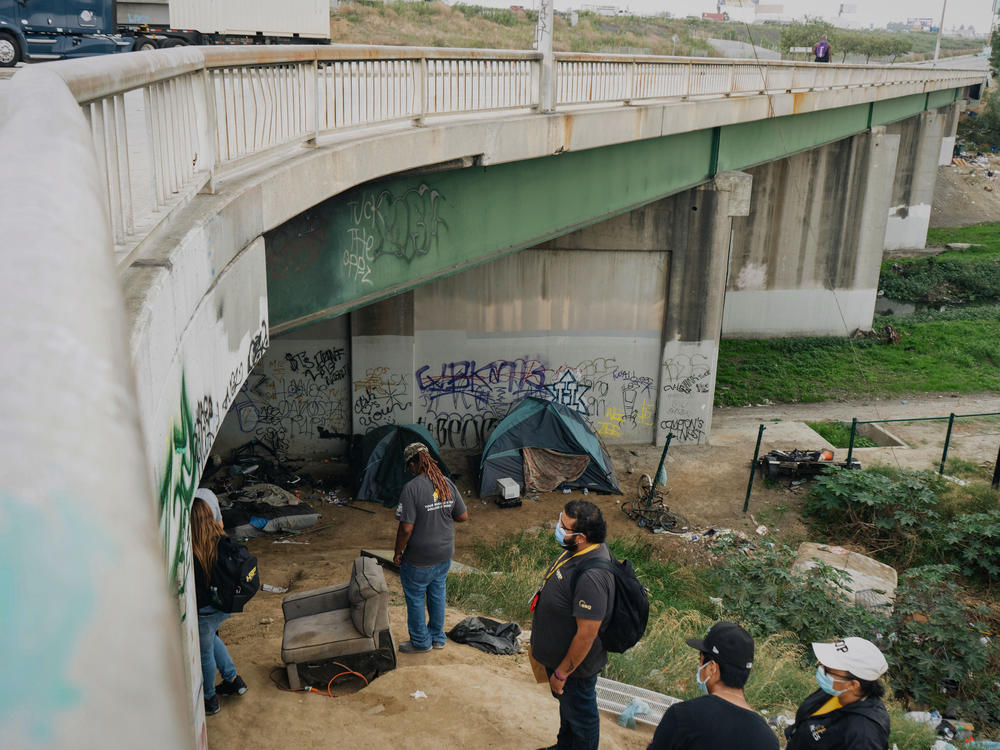 The HOPICS outreach team checks on people living under a highway bridge in South Los Angeles on Sept. 21.