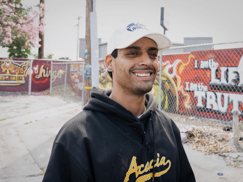 Andy Romero poses for a portrait near the tent where he lives in South L.A. Romero says he grew up in this area but has been without stable housing since his parents separated when he was 12.