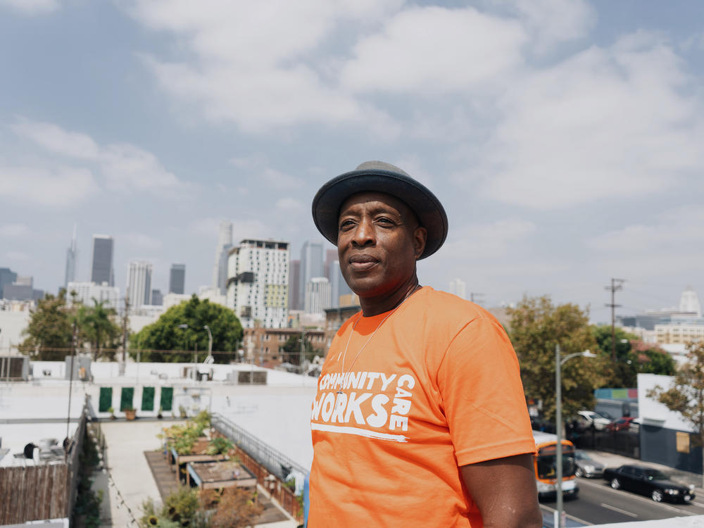 Pete White, a homelessness advocate who directs the LA Community Action Network, poses for a portrait against the skyline of downtown Los Angeles.
