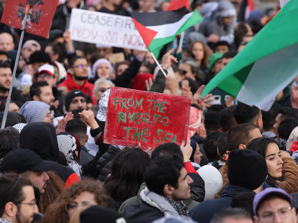 A demonstrator holds a sign reading 
