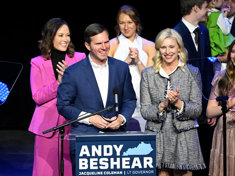Kentucky incumbent Democratic Gov. Andy Beshear is joined by his wife, Britainy Beshear (R), Kentucky Lt. Governor Jacqueline Coleman (L) and his family as he delivers his victory speech in Louisville on Tuesday.