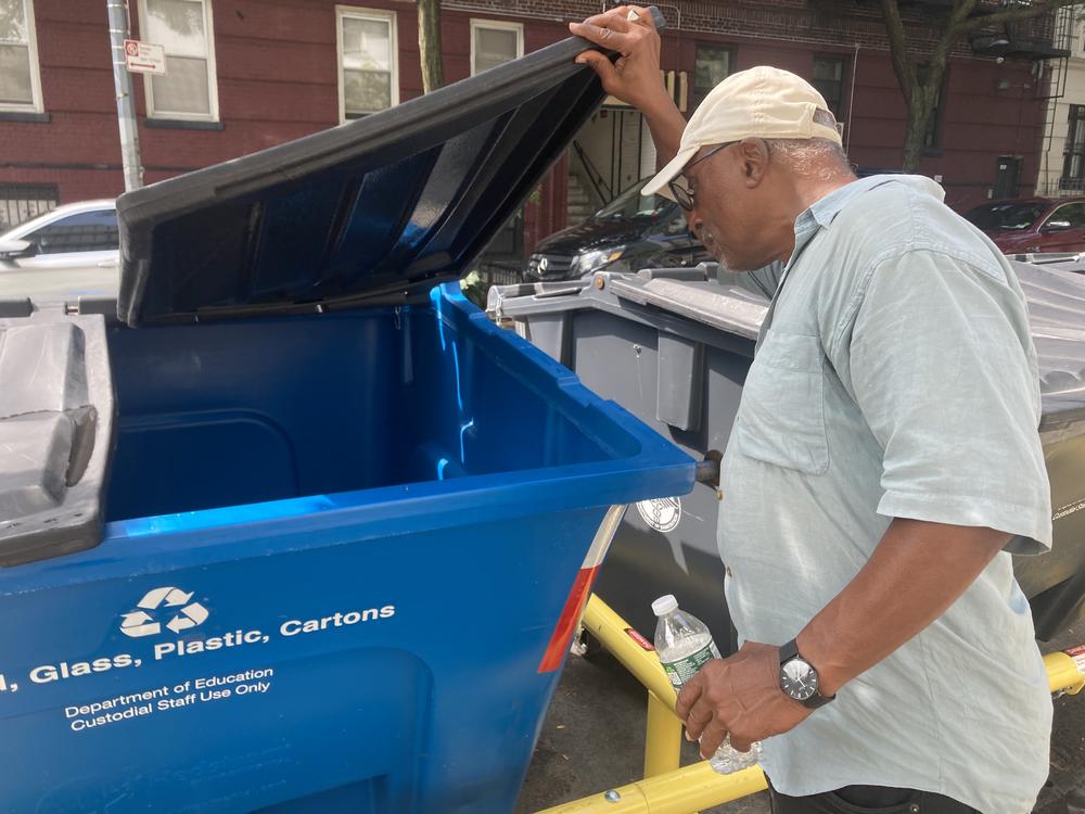 Victor Edwards, chair of Manhattan Community Board 9, looks inside a new waste container in West Harlem, New York City in September 2023.