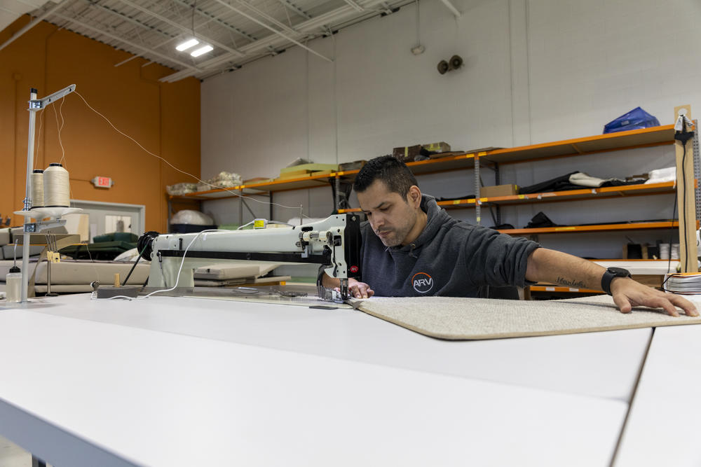 Master upholsterer Alex LLacsahuanga works on an industrial sewing machine that Advanced RV purchased as part of a push to find efficiencies. The sewing machine helps cut the time it takes to bind carpets.