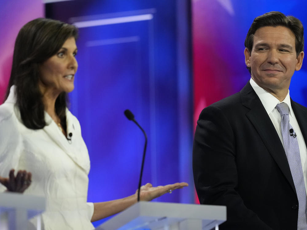 Republican presidential candidate former U.N. Ambassador Nikki Haley speaks as Florida Gov. Ron DeSantis listens during a Republican presidential primary debate hosted by NBC News on Wednesday in Miami.