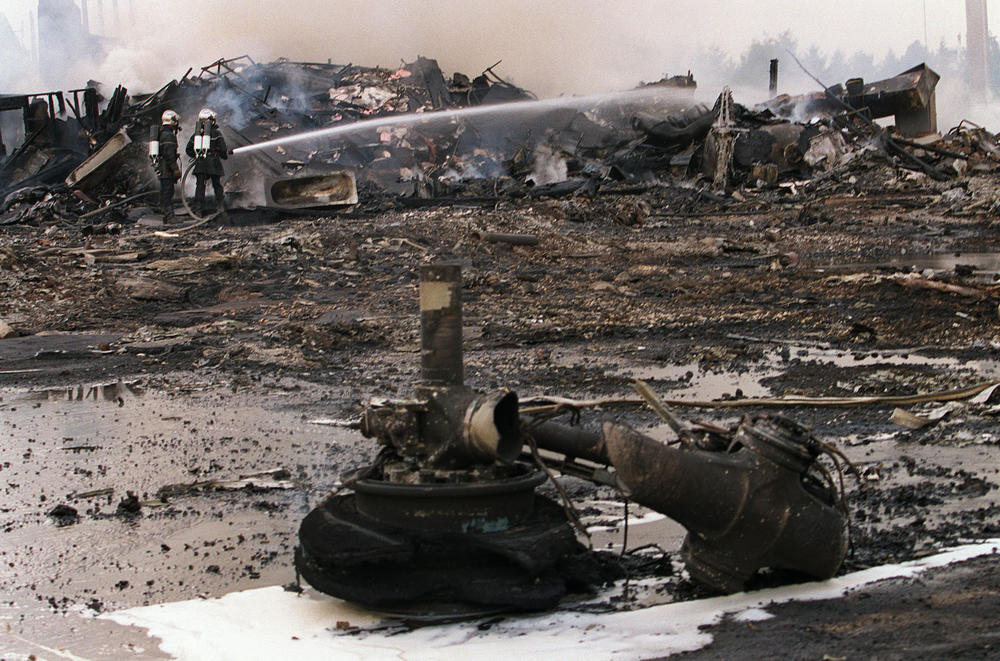 Firefighters spray water amid the debris of Air France Flight 4590. The Concorde crashed shortly after takeoff from Charles de Gaulle Airport on July 25, 2000.