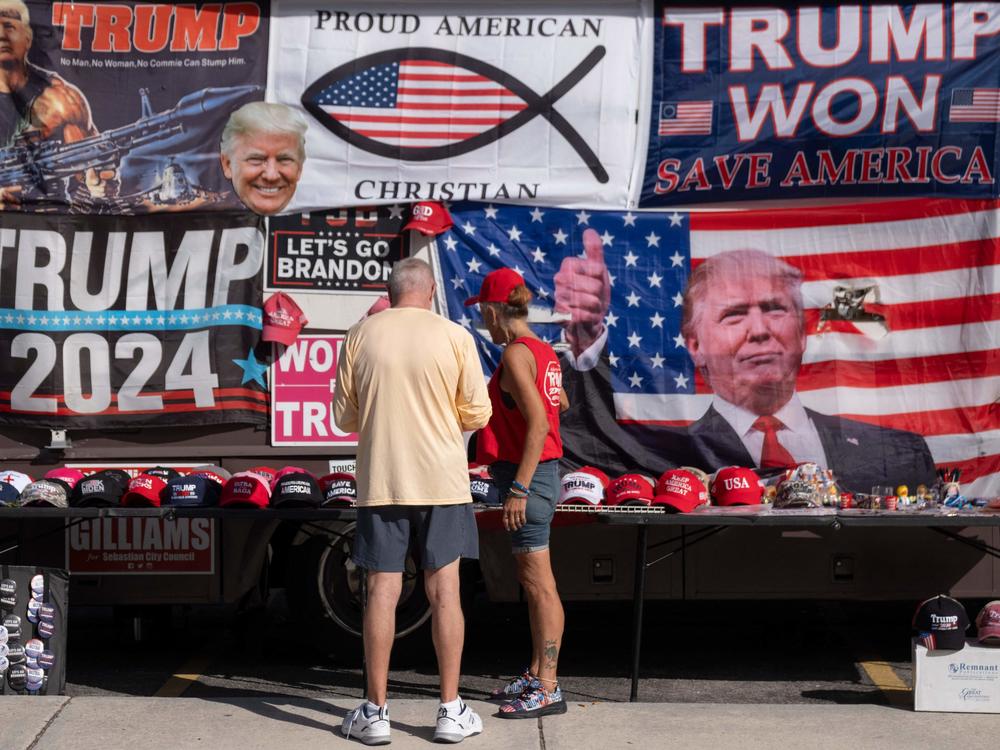 Supporters of former President Donald Trump look at merchandise ahead of his rally in Hialeah, Fla., this week. Trump continues to falsely claim he won the 2020 election, fueling conspiracy theories around the voting process.
