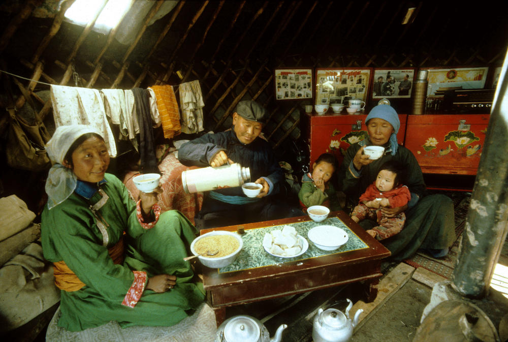 It's tea time for a Mongolian family in their <em>ger</em> (aka a yurt). It's easy to see why families that live in a yurt are ... close to each other.