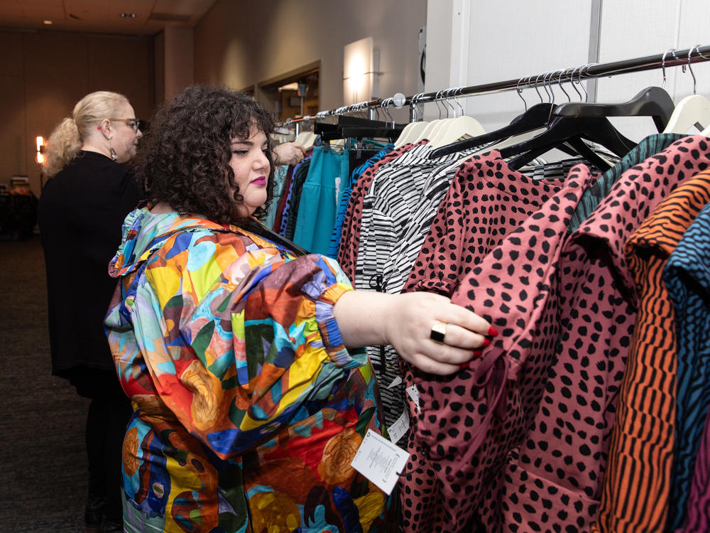 Alexis Krase, owner of Plus BKLYN, looks through a rack of clothes of the brand Lobo Mau at Philly FatCon last month. Krase was also a speaker at the event, as part of the 'Fat & Fashionable' panel.