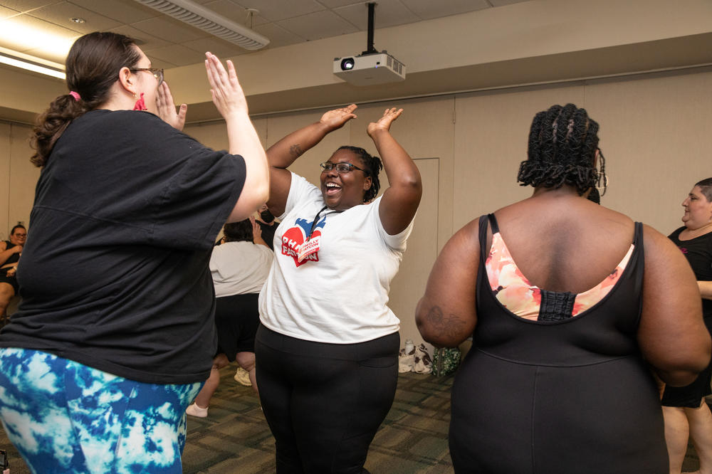 Attendees high-five each other at the end of the 'free the jiggle' wellness class taught by Jessie Diaz-Herrera at Philly FatCon last month.