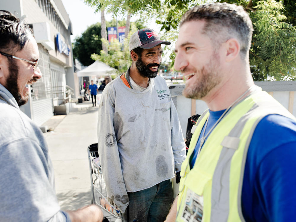 Veterans John Follmer, right, and Alejandro Rocha, left, do outreach on on Hollywood Boulevard in Los Angeles. They met Chris Brown, center, and offered to connect him with veterans services.