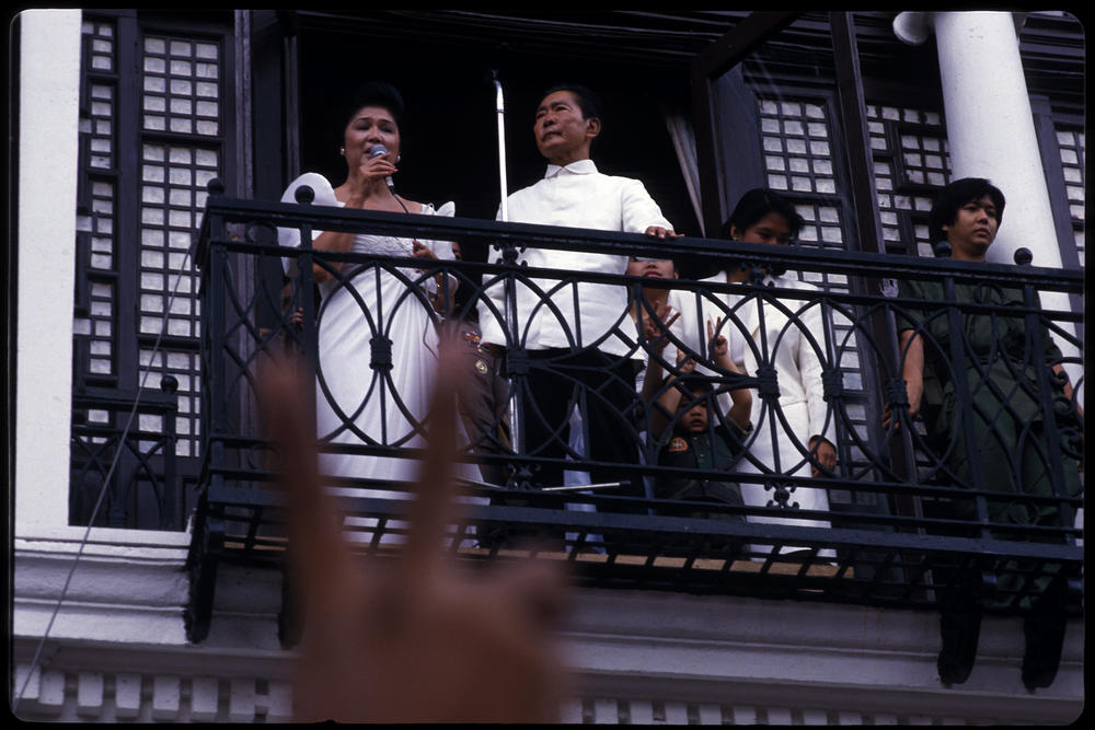 Ferdinand Marcos stands by as his wife Imelda sings to supporters from a balcony of the Malacanang Palace in Manila after Marcos's self administered inauguration ceremony as victor in the Philippine Presidential elections, 25th February 1986. Later in the evening they fled the palace aboard four American helicopters and were taken to Clarke Air Base enroute to exile in Hawaii.