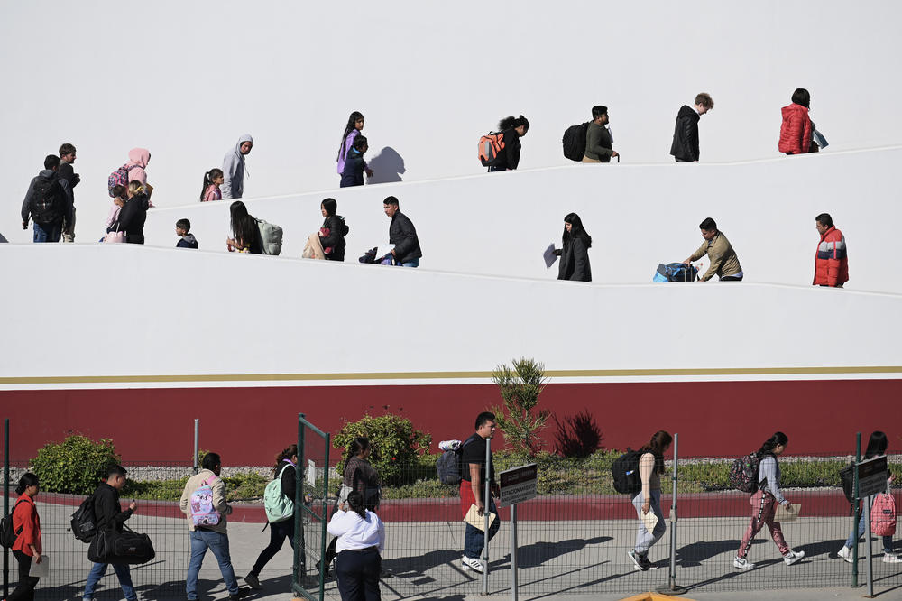 Migrants with CBP One asylum appointments at the Chaparral pedestrian border in Tijuana, Mexico cross into the U.S. on Thursday.