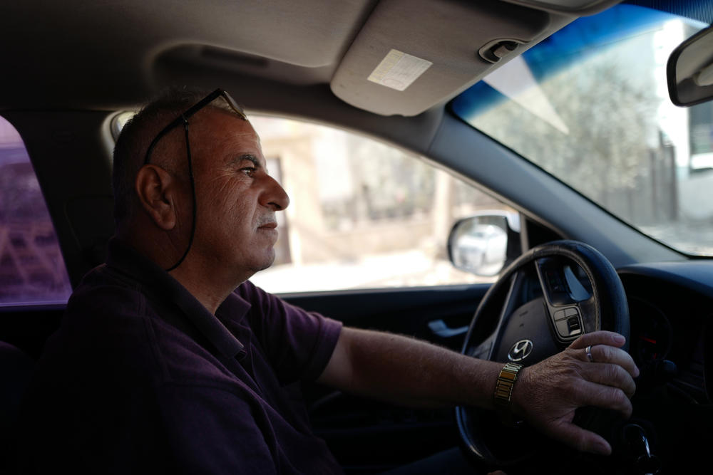 Abuhejleh drives towards his land and olive trees from his home in Deir Istiya.