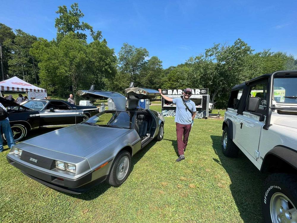Fernando Alfonso next to his DeLorean DMC-12 at a 2023 Independence Day car show in Brookhaven, Ga.