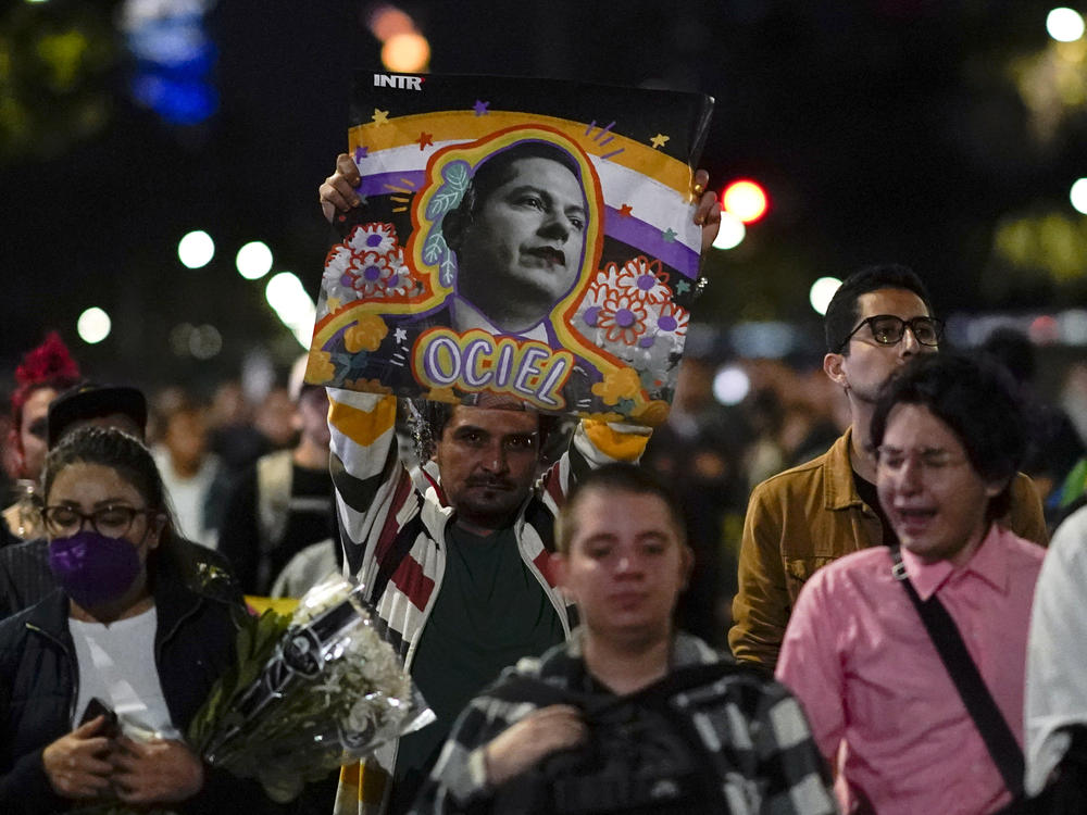 Demonstrators march with a picture of Aguascalientes state electoral court magistrate Jesus Ociel Baena in Mexico City, Monday, Nov. 13, 2023.