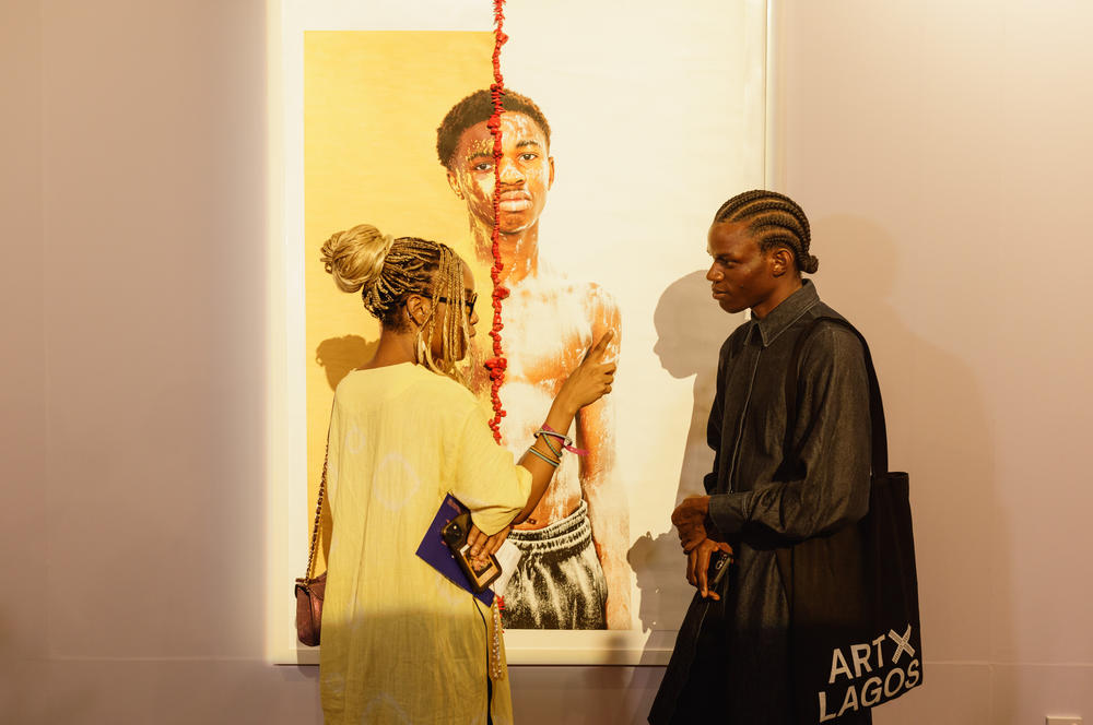 Artist Dafe Oboro (right), winner of the Nigerian Prize Award of the Access ART X Prize 2022/23, chats with an attendee at this year's Art X fair in Lagos.