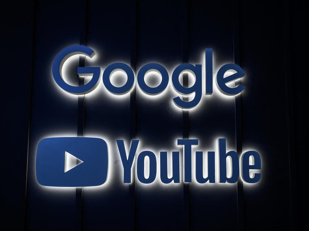 A photo shows the logo signs of Google and YouTube at their stand ahead of the World Economic Forum annual meeting in Davos in 2022.