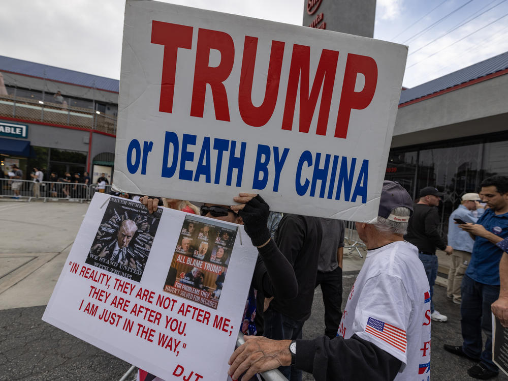 Supporters of former President Donald Trump hold anti-China signs as Trump visits an ice cream shop during in September.