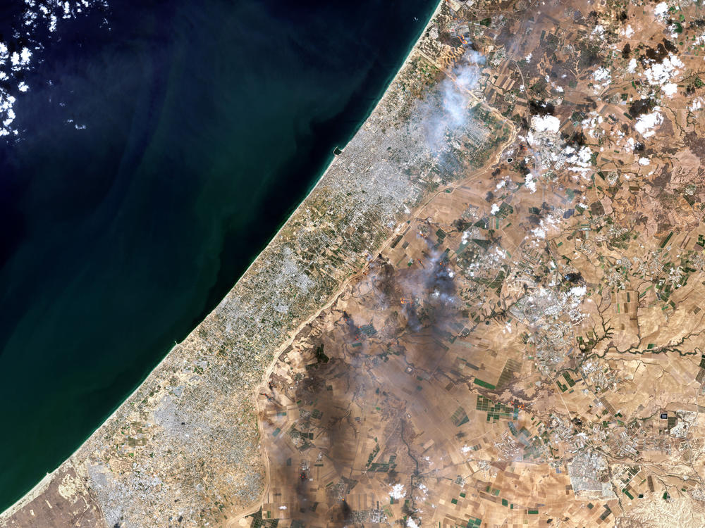 A satellite view shows smoke along the Gaza-Israel border on Oct. 7 in an image combining natural with shortwave-infrared highlights. The image came from a Copernicus Sentinel satellite run, by the EU space program.