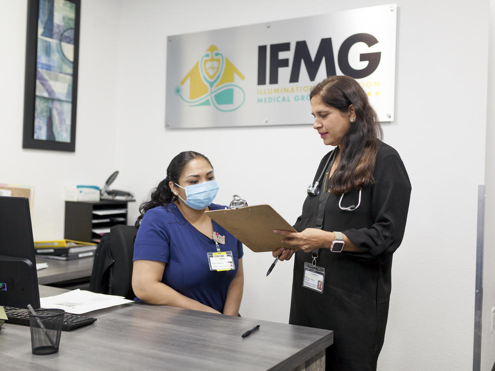 Illumination Foundation CEO Pooja Bhalla (right) reviews patient information with Nancy Bernabe (left) at the organization's medical center in Fullerton, California.