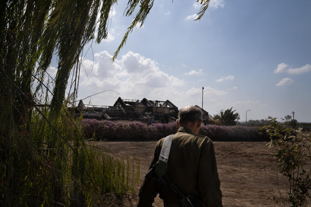 An Israeli soldier walks past destruction in Kibbutz Be'eri.