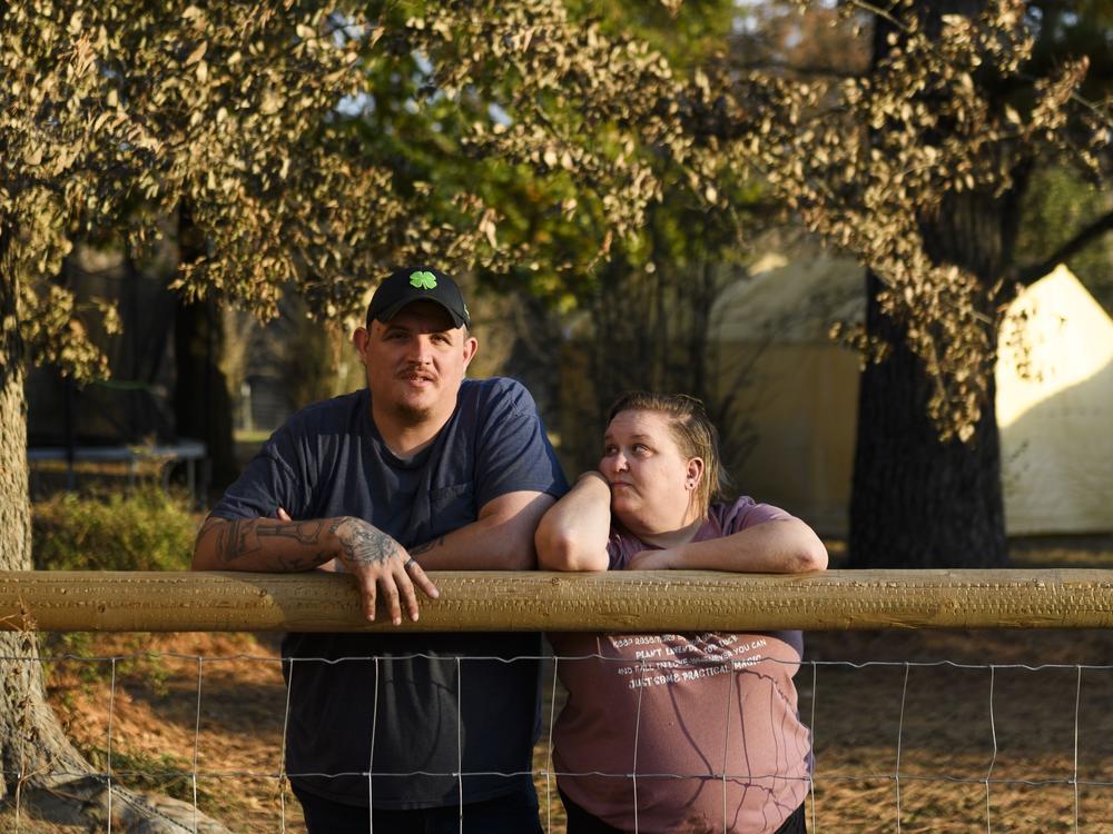 Army veteran Raymond Queen stands with his wife Rebecca Queen outside their home in Bartlesville, Okla.