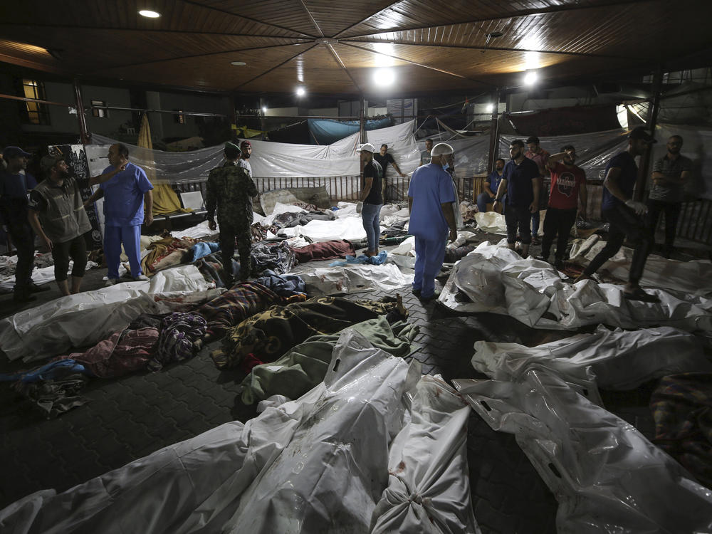 Bodies of Palestinians killed by an explosion at the Ahli Arab hospital are gathered in the front yard of Al Shifa hospital, in Gaza City, central Gaza Strip, on Oct. 17. Palestinians say the devastating war between Israel and Hamas is robbing them not only of their loved ones but also of the funeral rites that long have offered mourners some dignity and closure in the midst of grief.