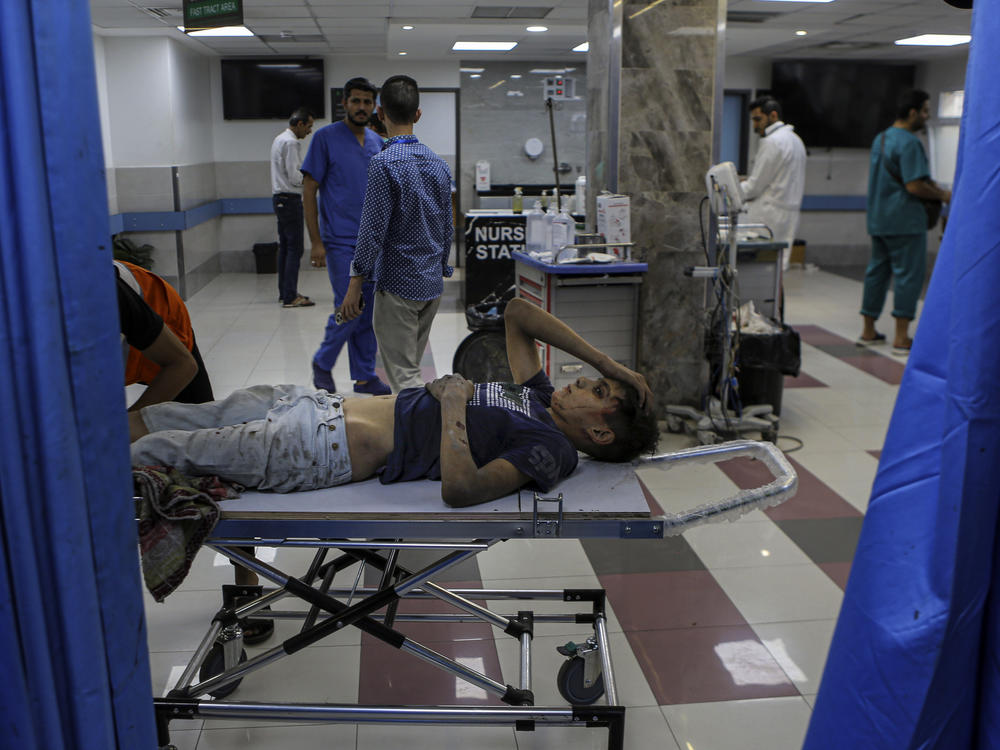 A wounded Palestinian boy arrives to the emergency room of the Al-Shifa hospital, following Israeli airstrikes on Gaza City, central Gaza Strip, on Oct. 17. Israel claims Hamas uses the facility for military purposes and has built a vast underground command center below the hospital. As Israeli forces move in on the facility, hundreds of doctors and patients remain inside.