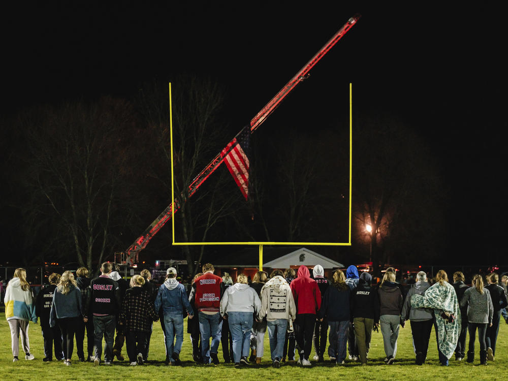 Students walk on the football field during a community prayer vigil, Tuesday, Nov. 14, 2023, at the Tuscarawas Valley Schools football stadium in Zoarville, Ohio.