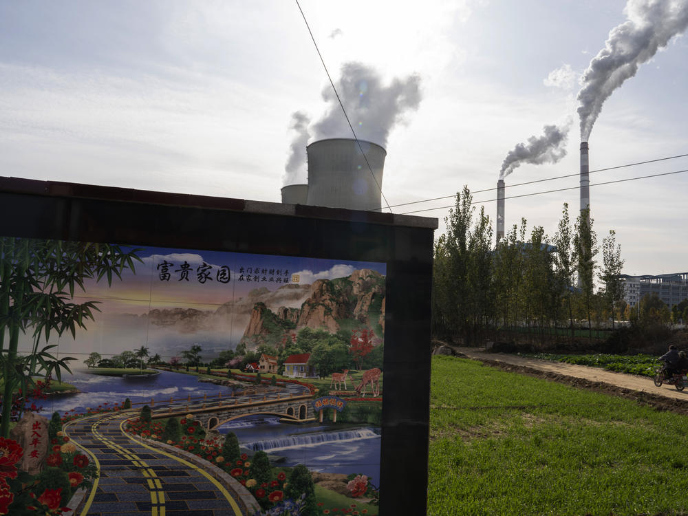 A resident rides past the Guohua Power Station in northern China's Hebei province. China and the U.S. have pledged to accelerate their efforts to address climate change ahead of a major U.N. meeting on the issue.