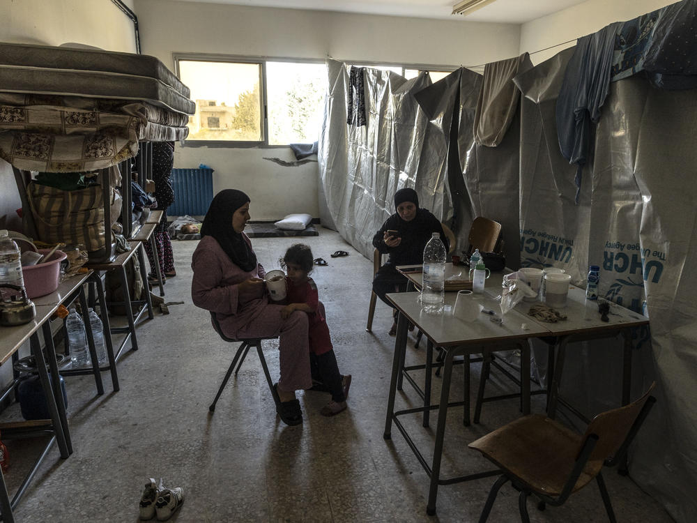 An internally displaced woman feeds her daughter at their room in a school reconverted as a temporary center for internally displaced people on Oct. 25, in Tyre, Lebanon. The International Organization for Migration reported 19,646 people had been displaced inside Lebanon since Oct. 8, the day after an assault on Israel by Hamas militants.