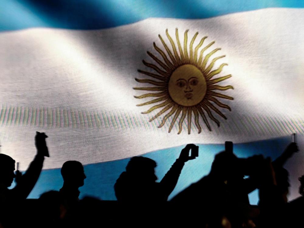 Against a backdrop of an Argentine flag, supporters of presidential candidate for La Libertad Avanza Alliance, Javier Milei, record with their mobile phones as he speaks during a campaign appearance.