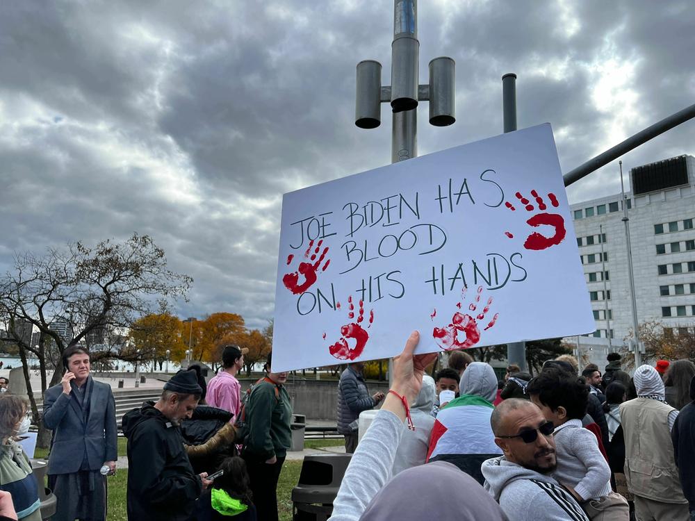 At a pro-Palestinian rally in Detroit, a protester holds up a sign saying 'Joe Biden has blood on his hands' in reference to the president's support for Israel. Hamas militants attacked Israel on Oct. 7, killing 1,200 people, according to the Israeli government. Israel's military offensive in response has killed 10,000 Palestinians, according to the Health Ministry of Gaza.