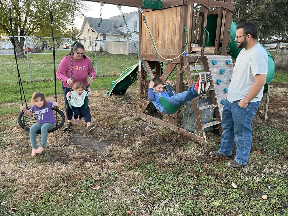 Joe and Alisha Bartleson play with their children on the swing set in their yard in Buffalo, Iowa. They think Donald Trump is the best Republican candidate to take on Joe Biden in 2024.