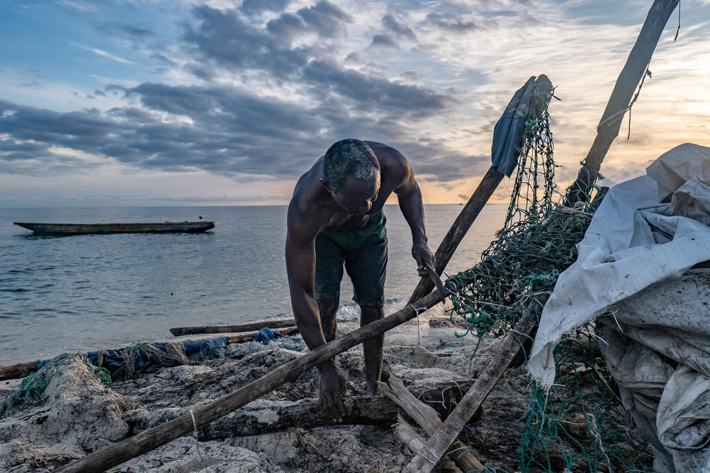 Mustafa Kong salvages building materials from the wreckage of his house, destroyed by flooding two weeks earlier, on Nyangai Island, Sierra Leone. 