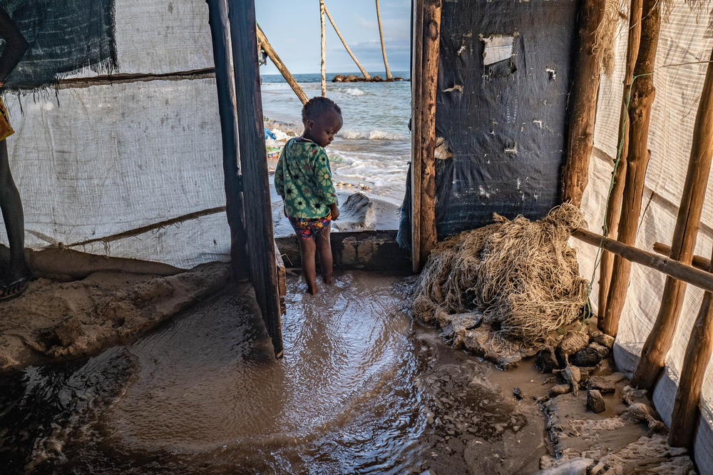 A boy looks on as seawater floods into his home on Nyangai Island, Sierra Leone. The island is rapidly being washed away by the encroaching sea.