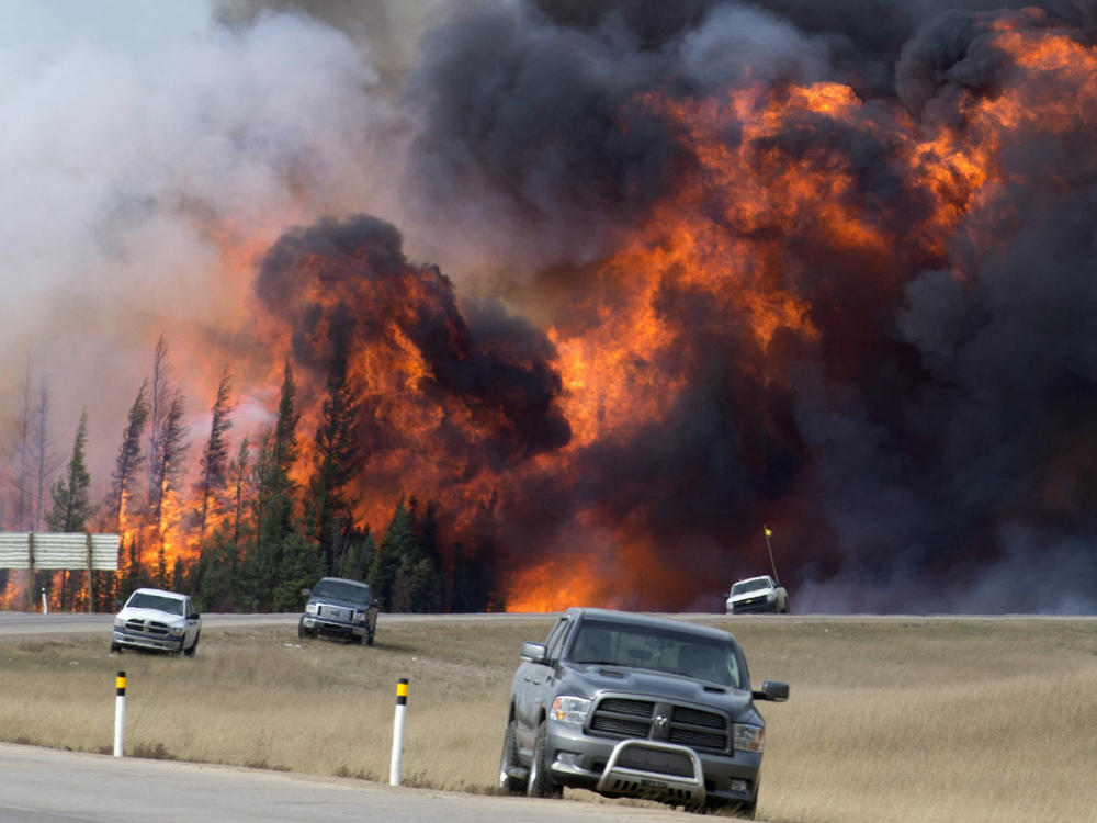 A wildfire burns south of Fort McMurray, Alberta, near Highway 63 on Saturday, May 7, 2016. A book about an inferno that ravaged a Canadian city and has been called a portent of climate chaos has won Britain's leading nonfiction book prize.