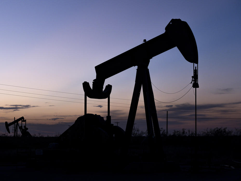 The sun sets behind pumpjacks on Sept. 15, 2021, in the oilfields of Penwell, Texas.