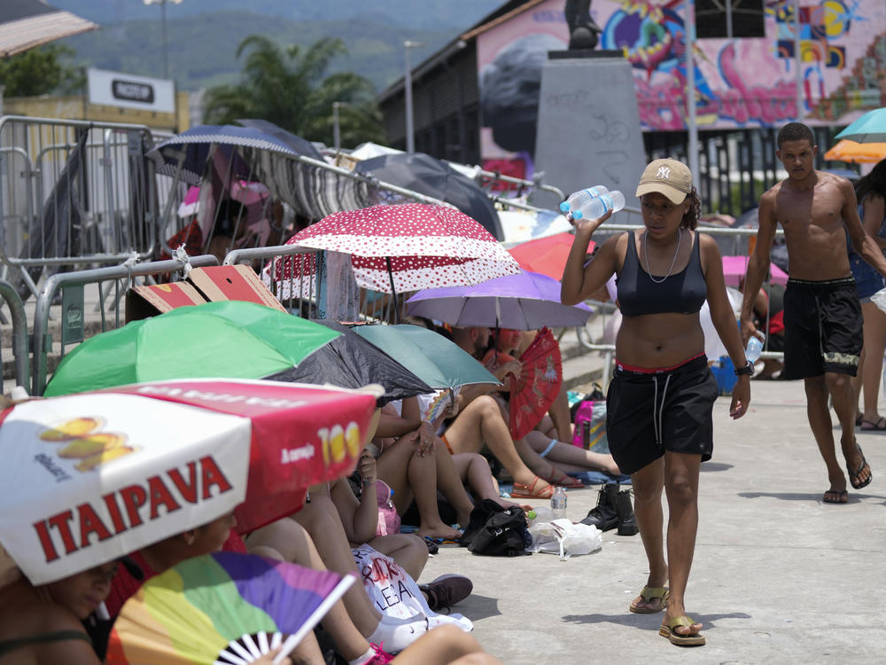Street vendors sell bottled water to Taylor Swift fans amid a heat wave before her Eras Tour concert outside the Nilton Santos Olympic stadium in Rio de Janeiro, Brazil, Saturday, Nov. 18, 2023.