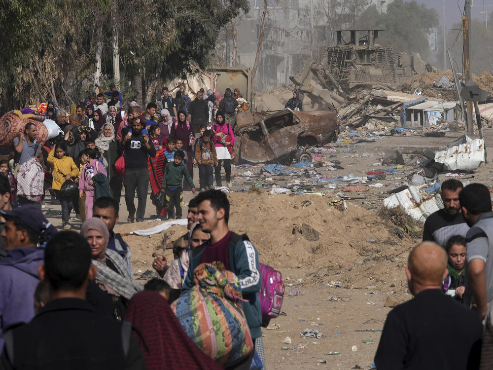 Palestinians flee to the southern Gaza Strip along Salah al-Din Street, on the outskirts of Gaza City, in front of an Israeli army bulldozer on Saturday.