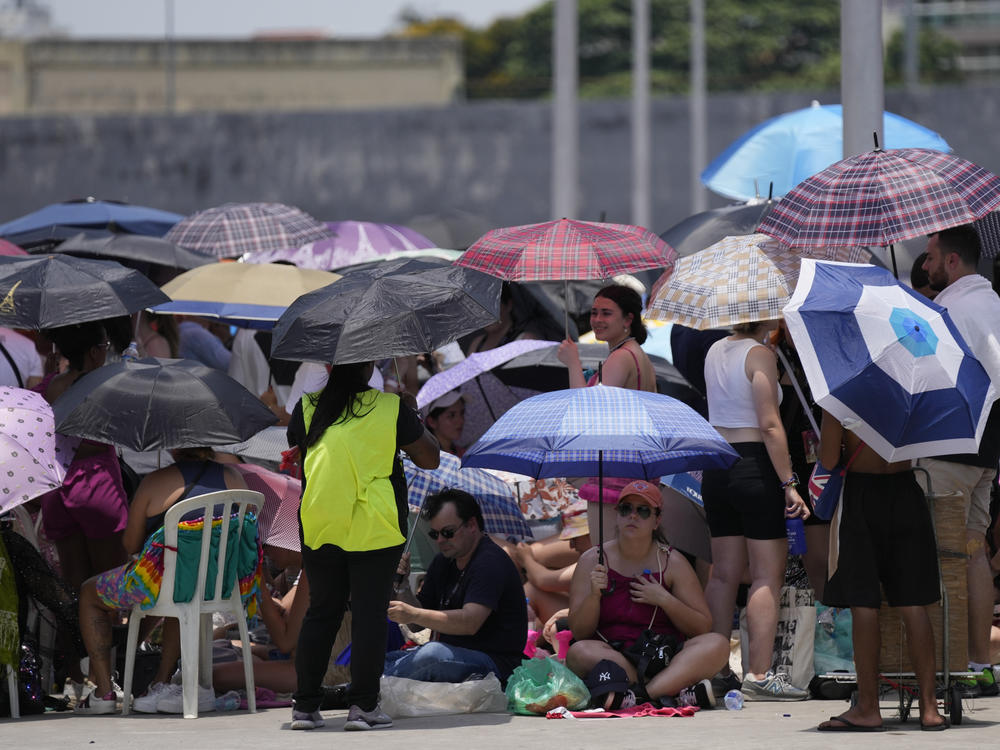 Taylor Swift fans wait for the doors of Nilton Santos Olympic stadium to open for her Eras Tour concert amid a heat wave in Rio de Janeiro, Brazil, Saturday, Nov. 18, 2023. A 23-year-old Taylor Swift fan died Friday night after suffering from cardiac arrest due to heat at the concert, according to a statement from the show's organizers in Brazil.