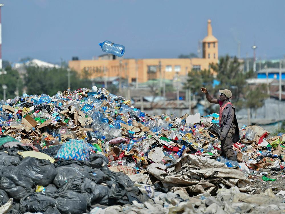 A man picks through plastic waste at a garbage dump in Kenya.