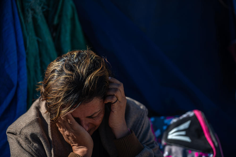 A migrant who came from Honduras after receiving threats because of her sexuality rests in Jacumba, Calif., after a long walk to the U.S.