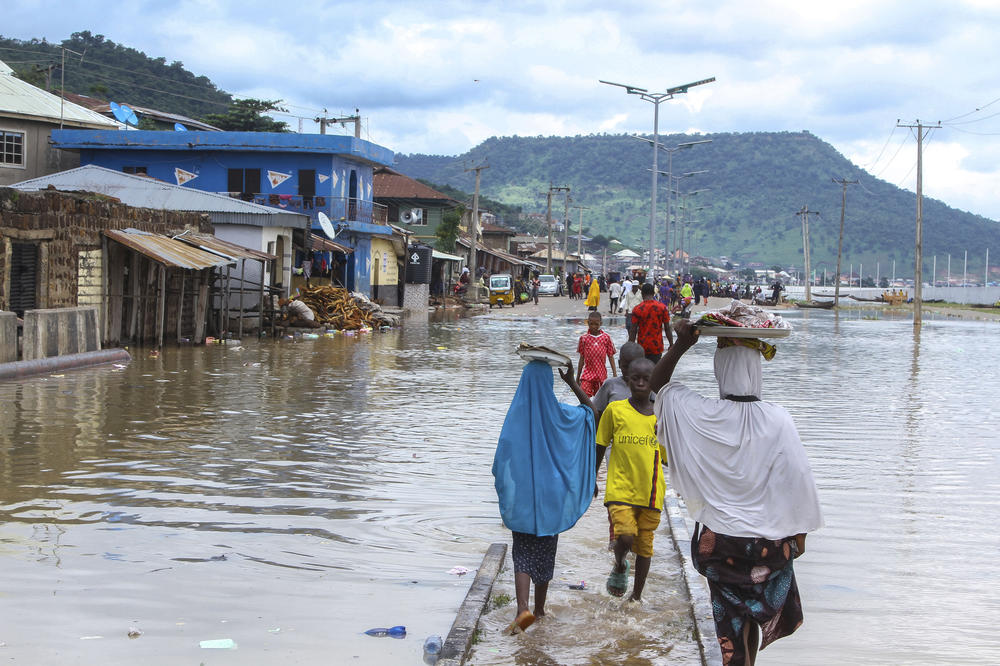 People are stranded by floods in Nigeria in 2022. Scientists say the intense rain and deadly flooding were made worse by climate change.